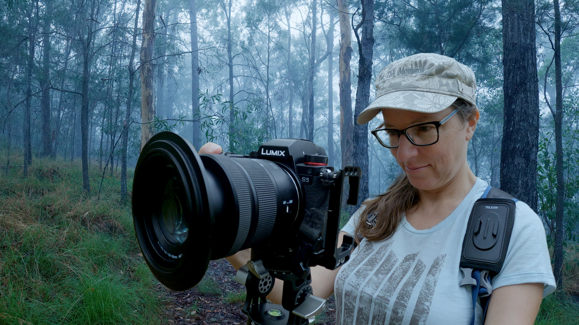 Lisa taking a photo in a misty woodland